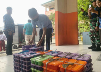 Petugas dapur MBG sedang menata hidangan sehat sebelum disajikan kepada siswa