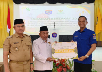 Direktur Perumda Tirta Alam Tarakan, Iwan Setiawan menyerahkan zakat profesi kepada Ketua Baznas Tarakan, K.H, Zainuddin Dalila